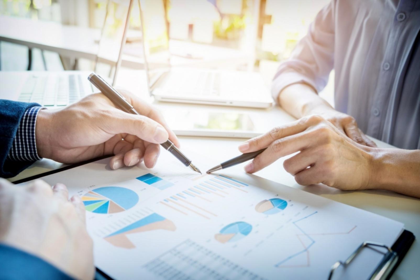 Schreibtisch mit offenen Notizbüchern und SEO-Strategien auf Papier